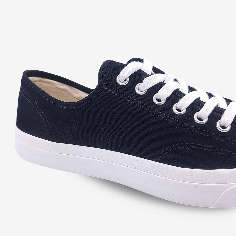 Close-up of Jack Purcell low black canvas sneaker with blue sole showing stitch detailing