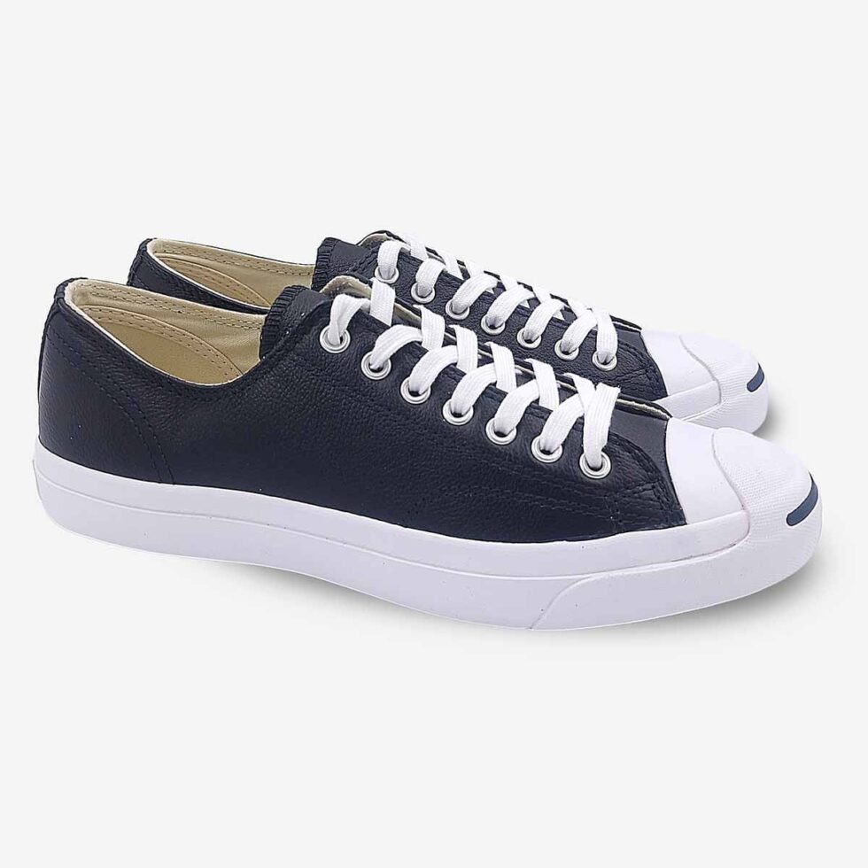Angled pair of Jack Purcell black leather low-top sneakers with blue sole underneath