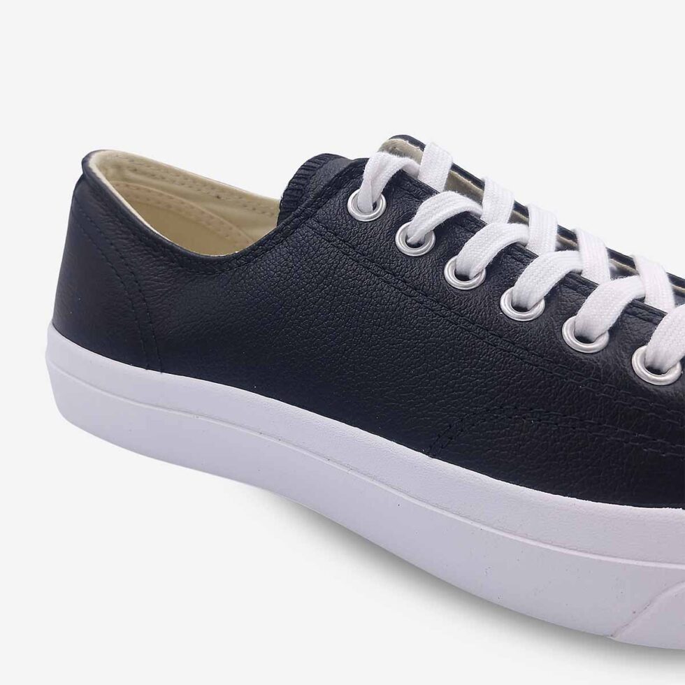 Close-up of Jack Purcell low black leather sneaker showing smooth leather and stitch detailing