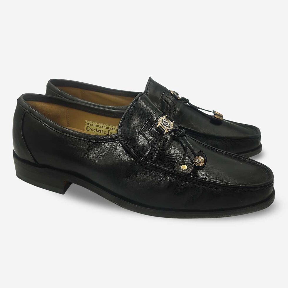 Pair of Crockett & Jones Glace Kid Black tassel loafers angled side view