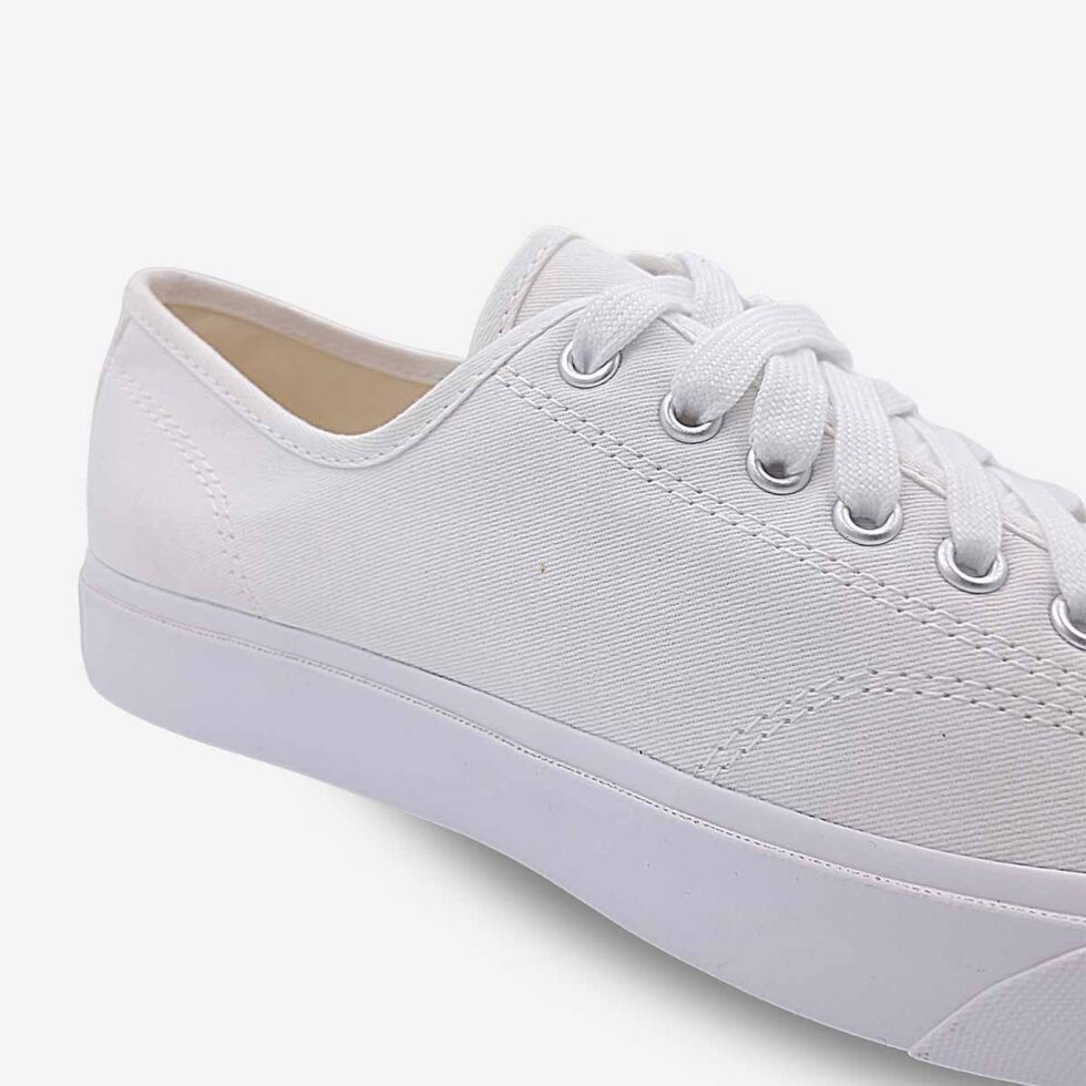 Close-up of Jack Purcell low white canvas sneaker showing clean stitching and lace-up front