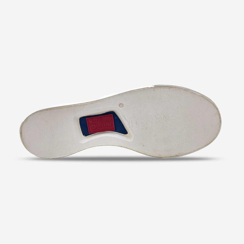 Underside view of Jack Purcell youth slip-on sneaker showing textured white rubber sole