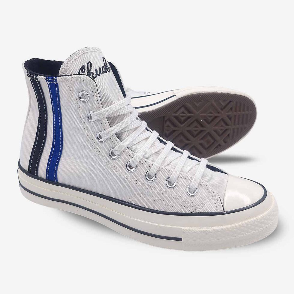 Angled pair view of Converse Chuck 70 Vintage White high-tops showing premium canvas and partial sole.