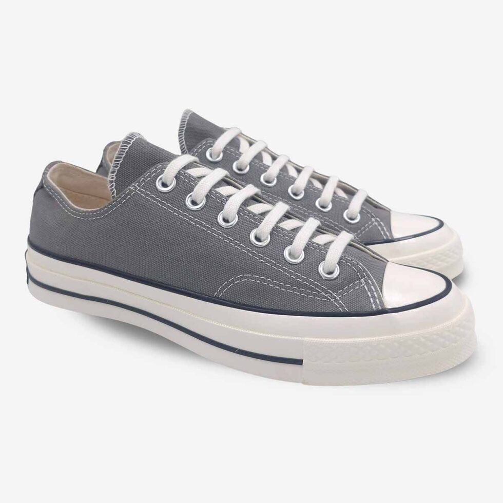 Angled pair of Converse Chuck 70 Low Grey sneakers showing profile and toe box detail.