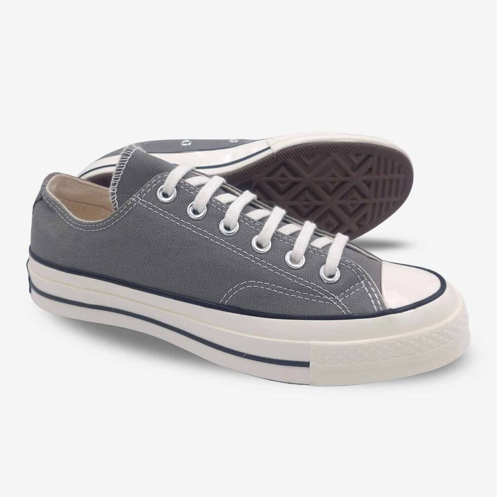 Angled pair of Converse Chuck 70 Low Grey sneakers showing vulcanized rubber sole and tread.