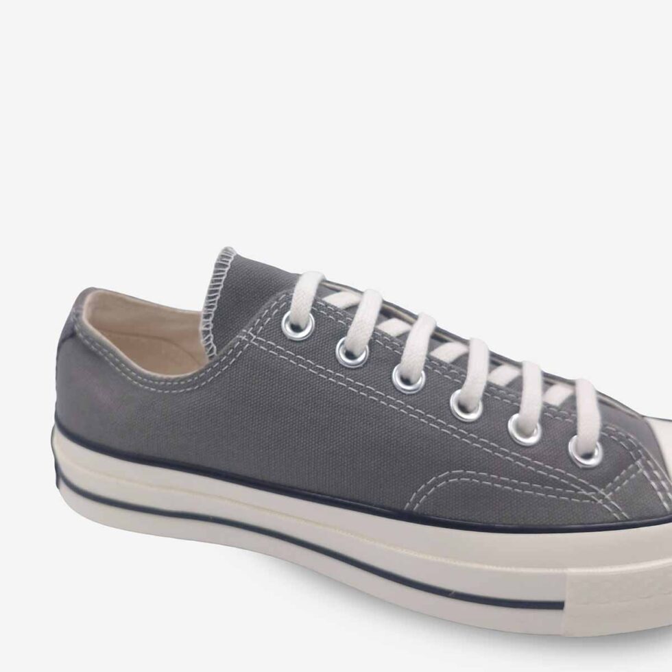 Close-up of Converse Chuck 70 Low Grey sneakers showing premium canvas and detailed stitching.