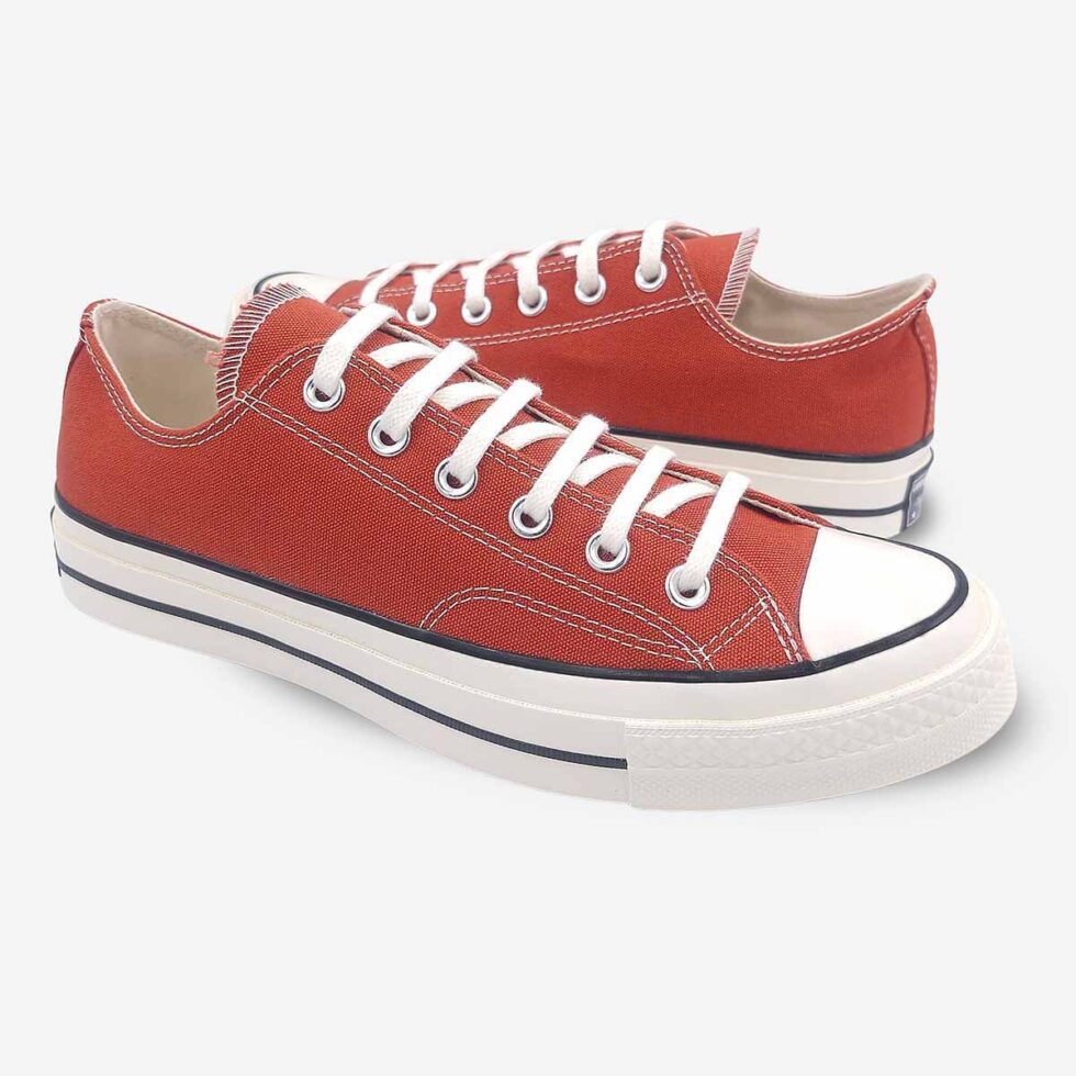 Mirrored pair of Converse Chuck 70 Low Red sneakers.